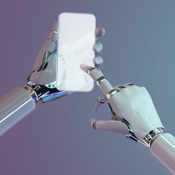 Eine humaniode Roboterhand hält ein Smartphone, die zweite Roboterhand tippt mit dem Zeigefinger auf die Oberfläche des Smartphones.